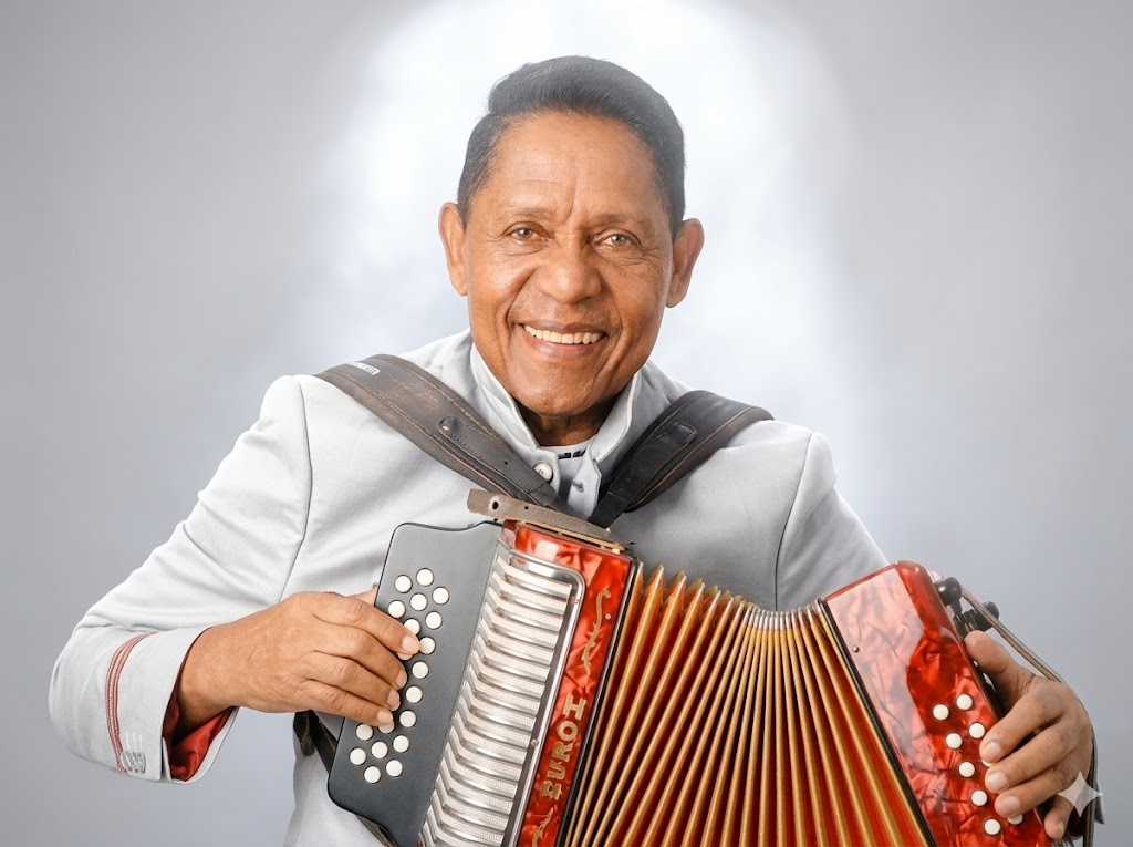 Israel Romero sonriendo mientras toca un acordeón rojo, homenajeado en el Festival Vallenato 2026.