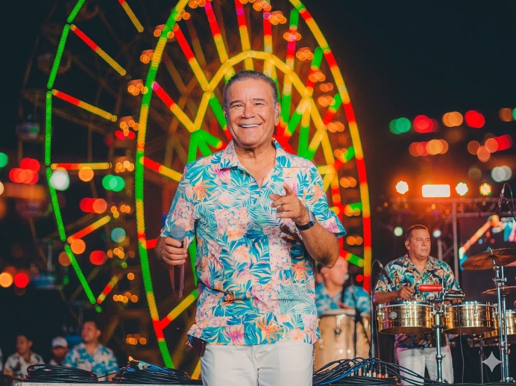 Iván Villazón cantando en el concierto 'Barranquilla está de moda' con la rueda iluminada Luna del Río de fondo en el Gran Malecón.