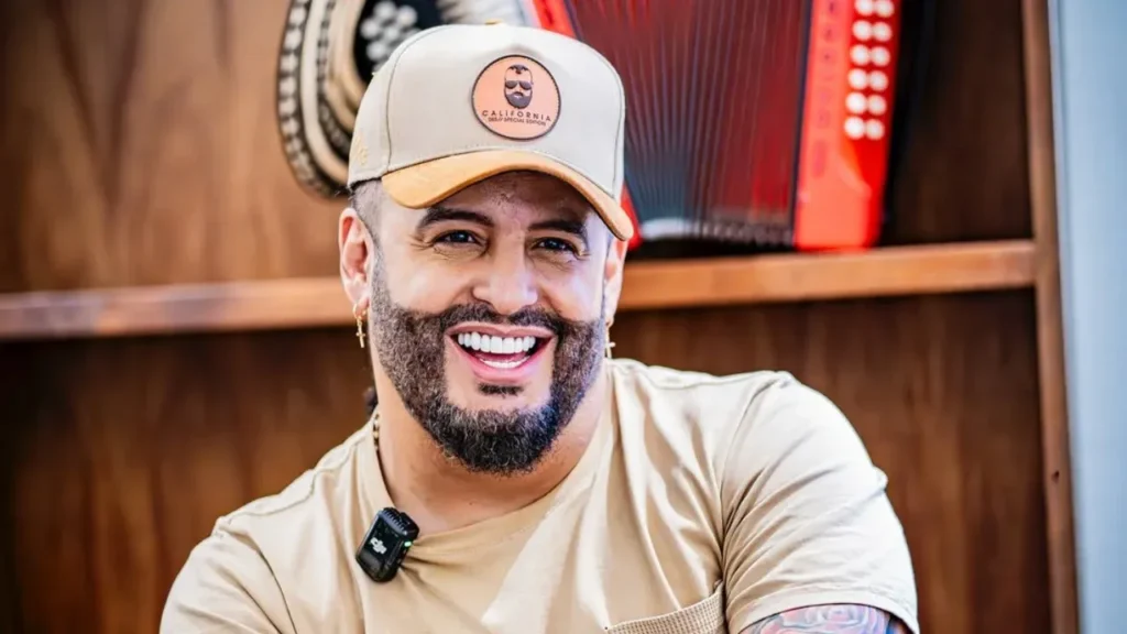 Nelson Velásquez sonriendo con un acordeón de fondo.